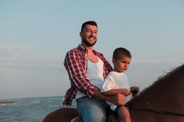 Father and son enjoy riding horses together by the sea. Selective focus —  Fotos de Stock