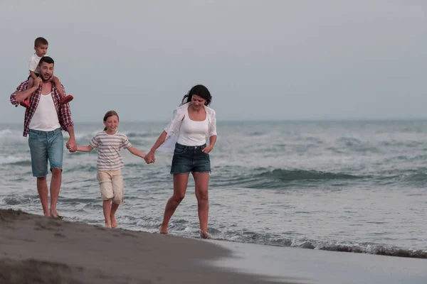 Rodzinne spotkania i spotkania towarzyskie na plaży o zachodzie słońca. Rodzina spaceruje po piaszczystej plaży. Skupienie selektywne — Zdjęcie stockowe