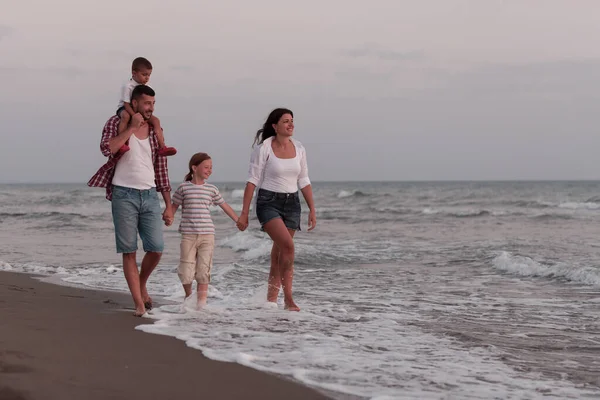 Rencontres familiales et socialisation sur la plage au coucher du soleil. La famille marche le long de la plage de sable fin. Concentration sélective — Photo