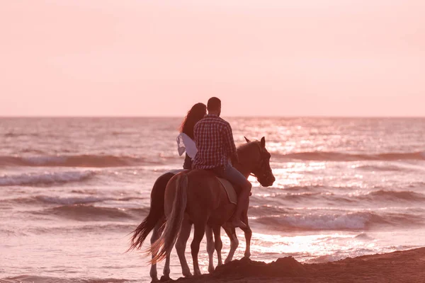 Η οικογένεια περνάει χρόνο με τα παιδιά της ενώ ιππεύει άλογα μαζί σε μια αμμώδη παραλία. Επιλεκτική εστίαση — Φωτογραφία Αρχείου
