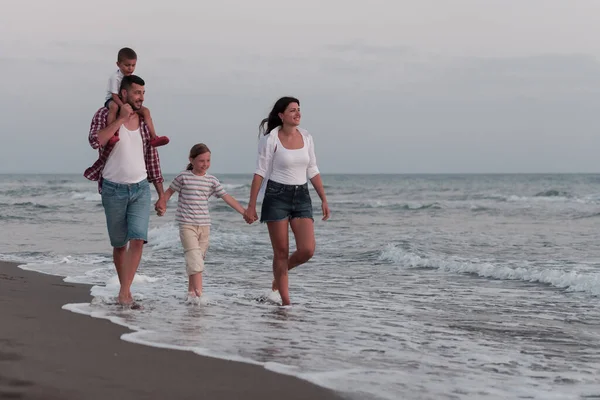 Rodzinne spotkania i spotkania towarzyskie na plaży o zachodzie słońca. Rodzina spaceruje po piaszczystej plaży. Skupienie selektywne — Zdjęcie stockowe