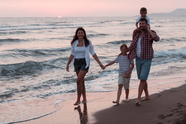 Aile toplantıları ve gün batımında sahilde sosyalleşme. Aile kumlu sahil boyunca yürür. Seçici odak 