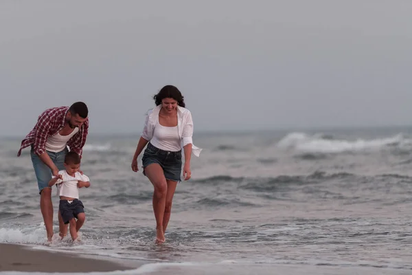 The family enjoys their vacation as they walk the sandy beach with their son. Selective focus Стоковая Картинка