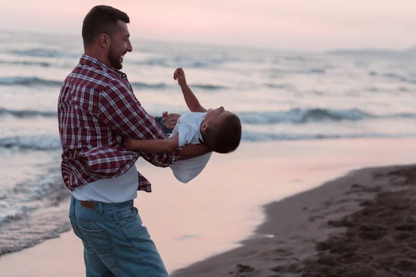 Feliz familia joven divertirse y vivir un estilo de vida saludable en la playa. Enfoque selectivo — Foto de Stock