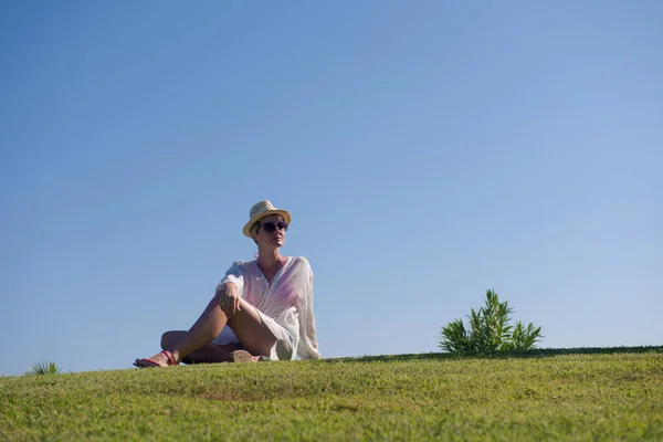 Mujer acostada y leyendo su libro favorito en un prado cubierto de hierba verde fresca en un soleado día de verano o primavera. —  Fotos de Stock