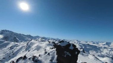 Havadan izleme sporu FPV İHA 'sı dağın tepesine yükseliyor. Alplerin güzel zirveleri kar örtüsüyle kaplıdır. Yüksek kalite 4k görüntü