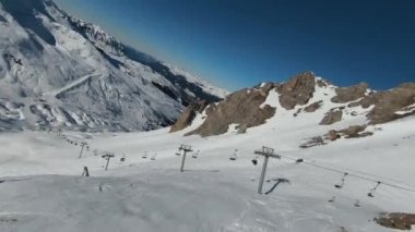 Havadan izleme sporu FPV İHA 'sı dağın tepesine yükseliyor. Alplerin güzel zirveleri kar örtüsüyle kaplıdır. Yüksek kalite 4k görüntü
