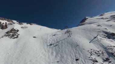 Havadan izleme sporu FPV İHA 'sı dağın tepesine yükseliyor. Alplerin güzel zirveleri kar örtüsüyle kaplıdır. Yüksek kalite 4k görüntü