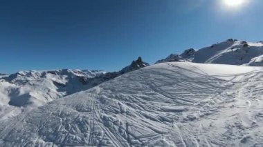 Havadan izleme sporu FPV İHA 'sı dağın tepesine yükseliyor. Alplerin güzel zirveleri kar örtüsüyle kaplıdır. Yüksek kalite 4k görüntü