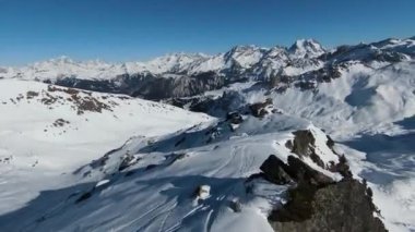 Havadan izleme sporu FPV İHA 'sı dağın tepesine yükseliyor. Alplerin güzel zirveleri kar örtüsüyle kaplıdır. Yüksek kalite 4k görüntü