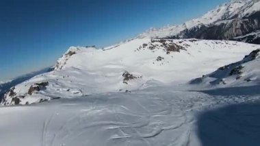Havadan izleme sporu FPV İHA 'sı dağın tepesine yükseliyor. Alplerin güzel zirveleri kar örtüsüyle kaplıdır. Yüksek kalite 4k görüntü