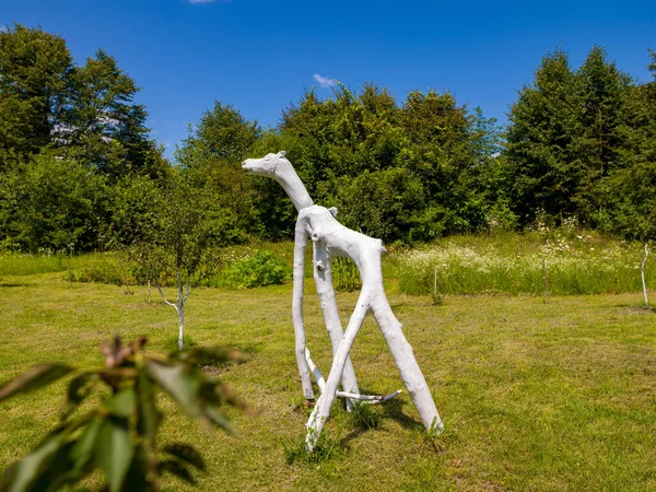 Ormanda geleneksel ahşap kır evi. Bahçesi ve renkli bitkileri var. Sanatsal heykeller.