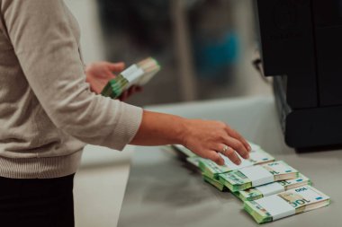 Bank employees holding a pile of paper banknotes while sorting and counting inside bank vault. Large amounts of money in the bank. High quality photo