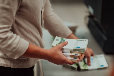 Banka çalışanları banka kasasında hesap yaparken elinde bir yığın kağıt banknot tutuyorlar. Bankada büyük miktarda para var. Yüksek kalite fotoğraf