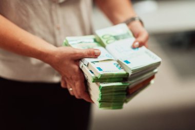 Banka çalışanları banka kasasında hesap yaparken elinde bir yığın kağıt banknot tutuyorlar. Bankada büyük miktarda para var. Yüksek kalite fotoğraf