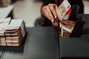 Sıralanmış banknotlar elektronik para sayma makinesine güvenildikten sonra masaya konur. Yüksek kalite fotoğraf