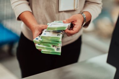 Banka çalışanları banka kasasında hesap yaparken elinde bir yığın kağıt banknot tutuyorlar. Bankada büyük miktarda para var. Yüksek kalite fotoğraf
