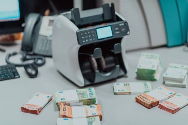 Sıralanmış banknotlar elektronik para sayma makinesine güvenildikten sonra masaya konur. Yüksek kalite fotoğraf