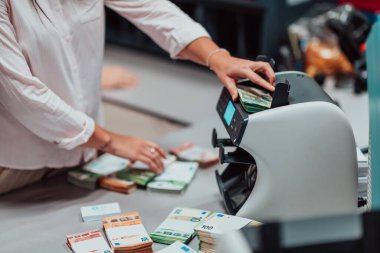 Bank employees using money counting machines while sorting and counting paper banknotes inside a bank vault. Large amounts of money in the bank. High quality photo