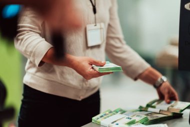 Bank employees holding a pile of paper banknotes while sorting and counting inside bank vault. Large amounts of money in the bank. High quality photo
