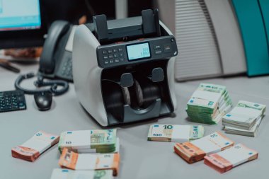 Sıralanmış banknotlar elektronik para sayma makinesine güvenildikten sonra masaya konur. Yüksek kalite fotoğraf