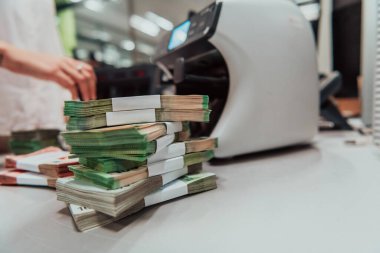Bank employees using money counting machines while sorting and counting paper banknotes inside a bank vault. Large amounts of money in the bank. High quality photo