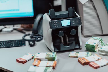 Sıralanmış banknotlar elektronik para sayma makinesine güvenildikten sonra masaya konur. Yüksek kalite fotoğraf