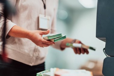 Bank employees holding a pile of paper banknotes while sorting and counting inside bank vault. Large amounts of money in the bank. High quality photo
