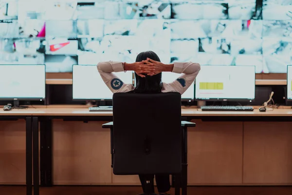 Female security operator working in a data system control room offices Technical Operator Working at the workstation with multiple displays, a security guard working on multiple monitors. High quality