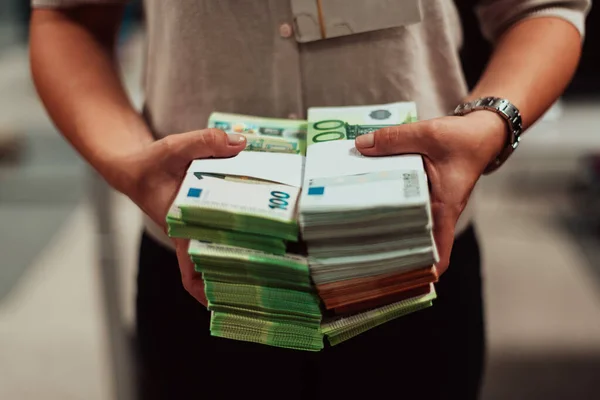 Bank employees holding a pile of paper banknotes while sorting and counting inside bank vault. Large amounts of money in the bank. High quality photo