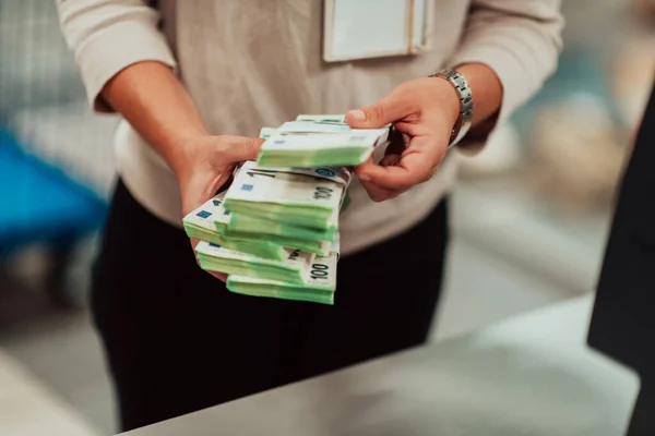 Bank employees holding a pile of paper banknotes while sorting and counting inside bank vault. Large amounts of money in the bank. High quality photo