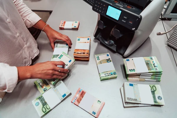 Bank employees using money counting machines while sorting and counting paper banknotes inside a bank vault. Large amounts of money in the bank. High quality photo