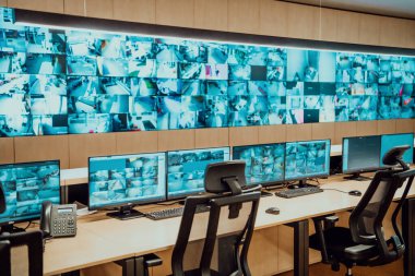 Büyük, modern güvenlik kontrol odasının içi boş, birden fazla ekranı olan çalışma istasyonu, güvenlik veri merkezindeki izleme odası boş ofis, masa ve ana CCTV güvenlik verilerindeki sandalyeler.
