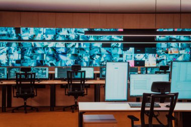 Büyük, modern güvenlik kontrol odasının içi boş, birden fazla ekranı olan çalışma istasyonu, güvenlik veri merkezindeki izleme odası boş ofis, masa ve ana CCTV güvenlik verilerindeki sandalyeler.