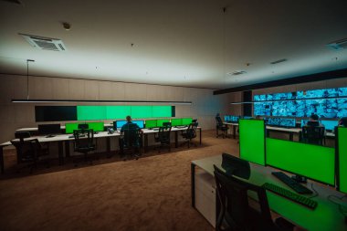 Male security operator working in a data system control room offices Technical Operator Working at workstation with multiple displays, security guard working on multiple monitors Male computer opera