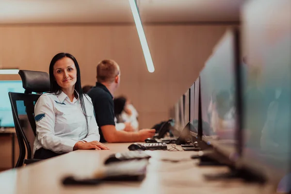 Female security operator working in a data system control room offices Technical Operator Working at the workstation with multiple displays, a security guard working on multiple monitors. High quality