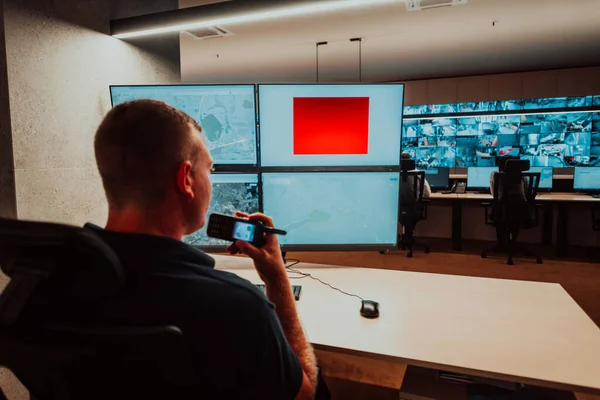 Male security operator working in a data system control room offices Technical Operator Working at workstation with multiple displays, security guard working on multiple monitors Male computer opera