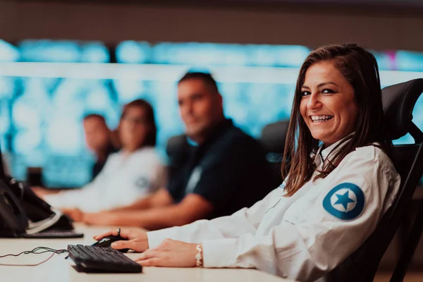 Group of Security data center operators working in a CCTV monitoring room looking on multiple monitors Officers Monitoring Multiple Screens for Suspicious Activities Team working on the System Contr