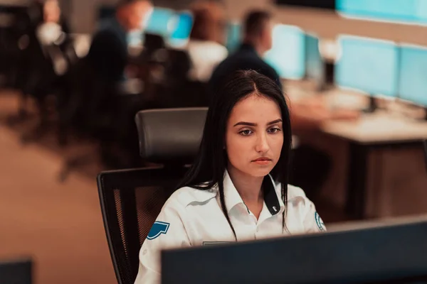 Female security operator working in a data system control room offices Technical Operator Working at the workstation with multiple displays, a security guard working on multiple monitors. High quality