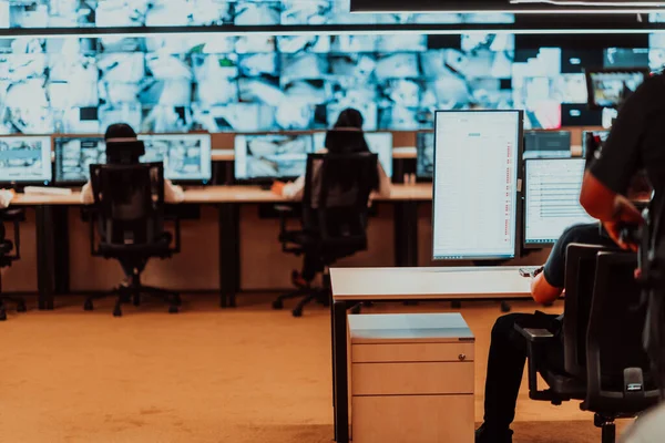 Male security operator working in a data system control room offices Technical Operator Working at workstation with multiple displays, security guard working on multiple monitors Male computer opera