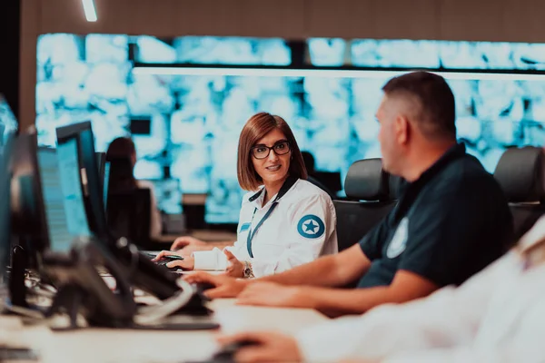 Group of Security data center operators working in a CCTV monitoring room looking on multiple monitors Officers Monitoring Multiple Screens for Suspicious Activities Team working on the System Contr