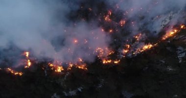 Aerial panoramic view of a forest fire at night, heavy smoke causes air pollution, and fire in full blaze. Natural disaster epic drone cinematic shot. Hi quality 4k footage.