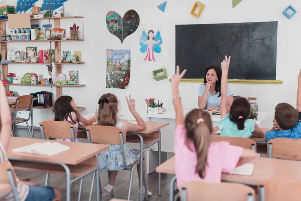 Elementary School Female Teacher Helps Child Student While Writing Answer — Zdjęcie stockowe