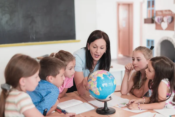 Female Teacher Kids Geography Class Looking Globe Side View Group — Stock Fotó