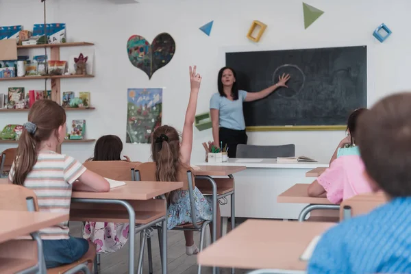 Elementary School Female Teacher Helps Child Student While Writing Answer — Foto Stock