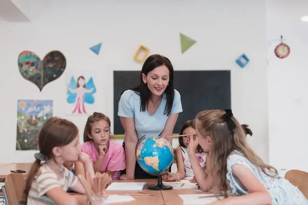 Female Teacher Kids Geography Class Looking Globe Side View Group — стоковое фото