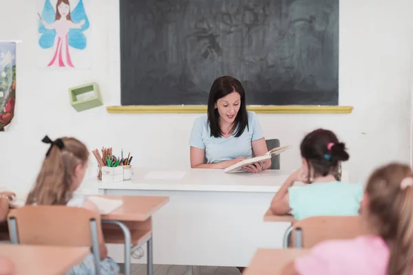 Teacher Reads Book Elementary School Students Who Listen Carefully While — Φωτογραφία Αρχείου
