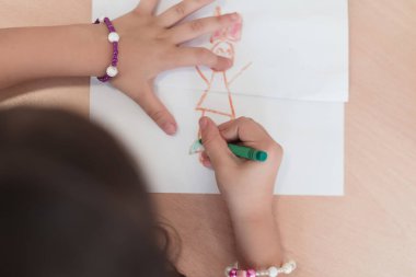 Little girls sitting in elementary school drawing on paper. High quality photo