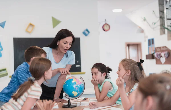 Female Teacher Kids Geography Class Looking Globe Side View Group — Foto Stock