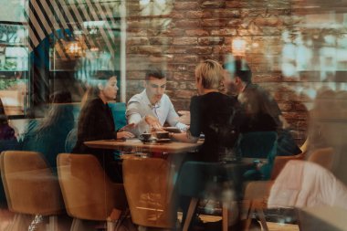 Happy businesspeople smiling cheerfully during a meeting in a creative office. Group of successful business professionals working as a team in a multicultural workplace. High quality photo